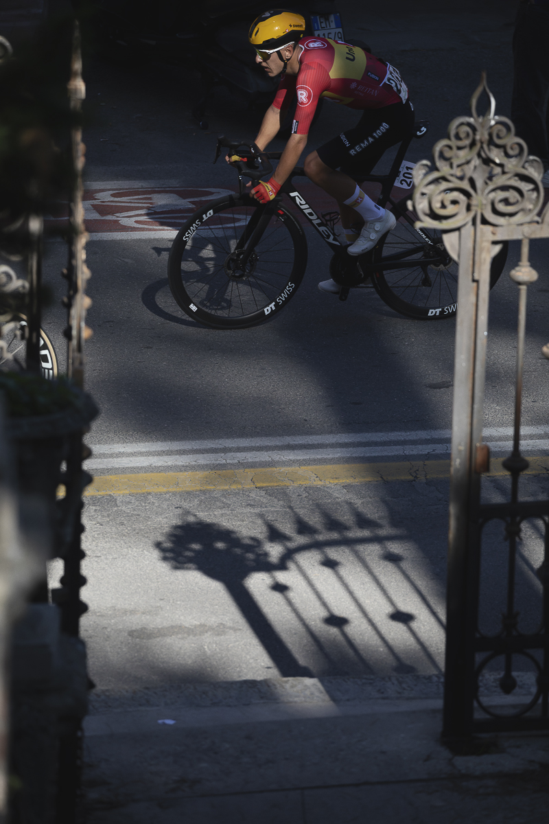 Giro dell’Emilia 2025 - Tobias Halland Johannessen passes by ornate gates in Bologna