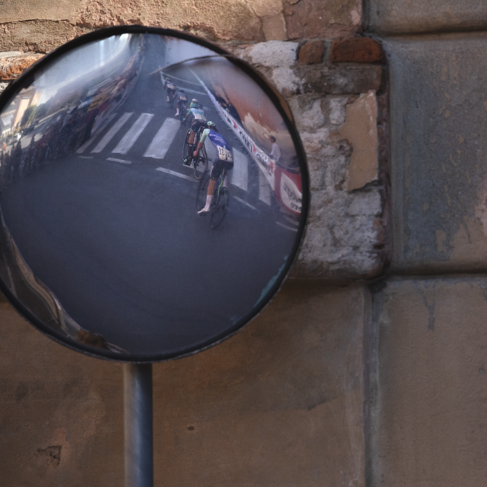 Giro dell’Emilia 2025 - Riders reflected in a mirror on the Via di San Luca