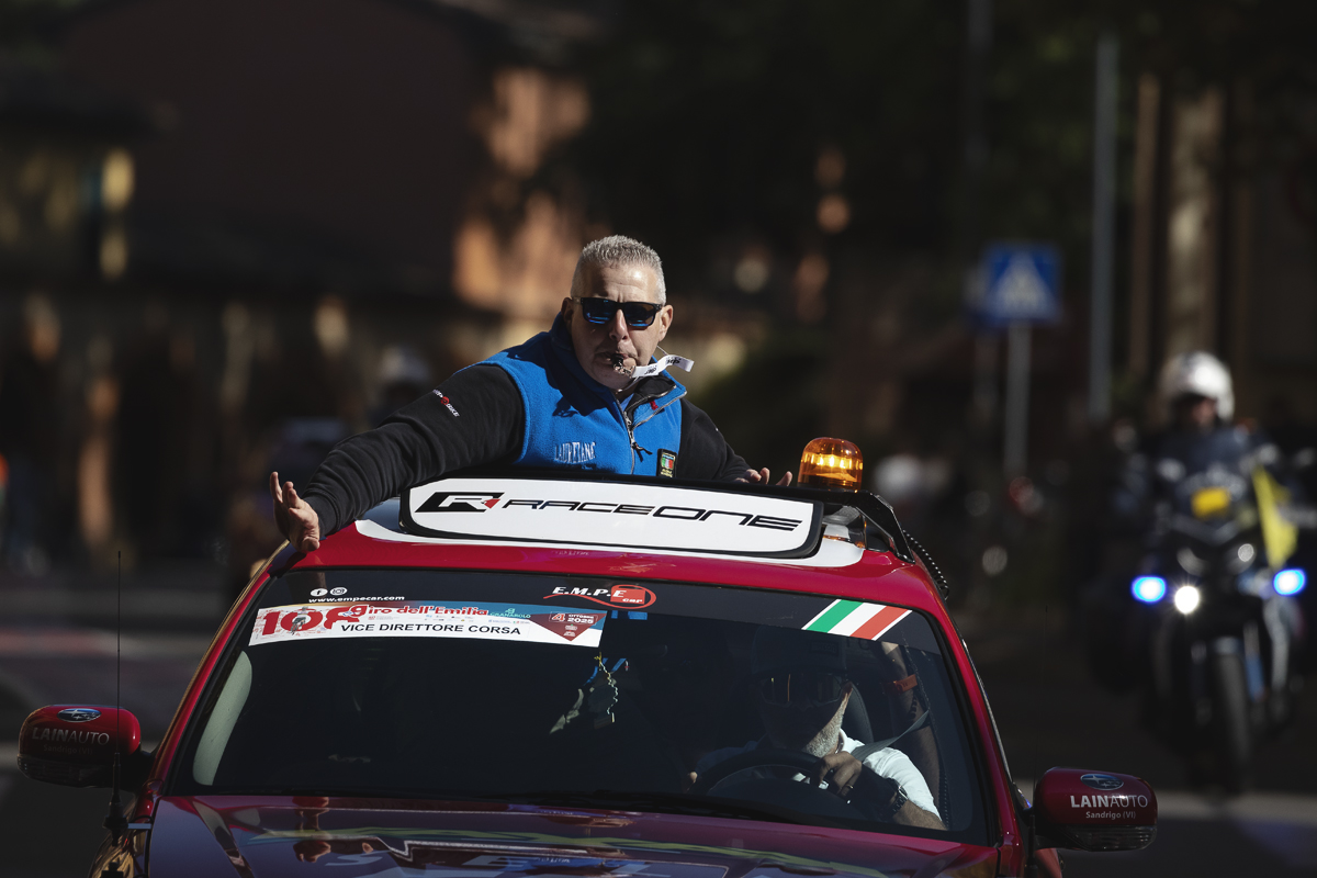 Giro dell’Emilia 2025 - Vice Direttore Corsa emerges from the sun roof of a car whistle in mouth