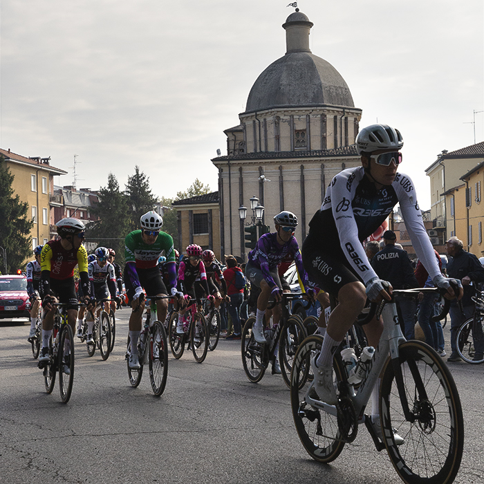 Giro dell’Emilia 2025 - The race rolls out of Mirandola against the backdrop of a domed church