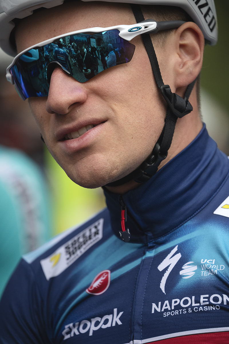 Giro dell’Emilia 2025 - Ethan Hayter, his team mates reflected in his glasses, waits for the team presentation