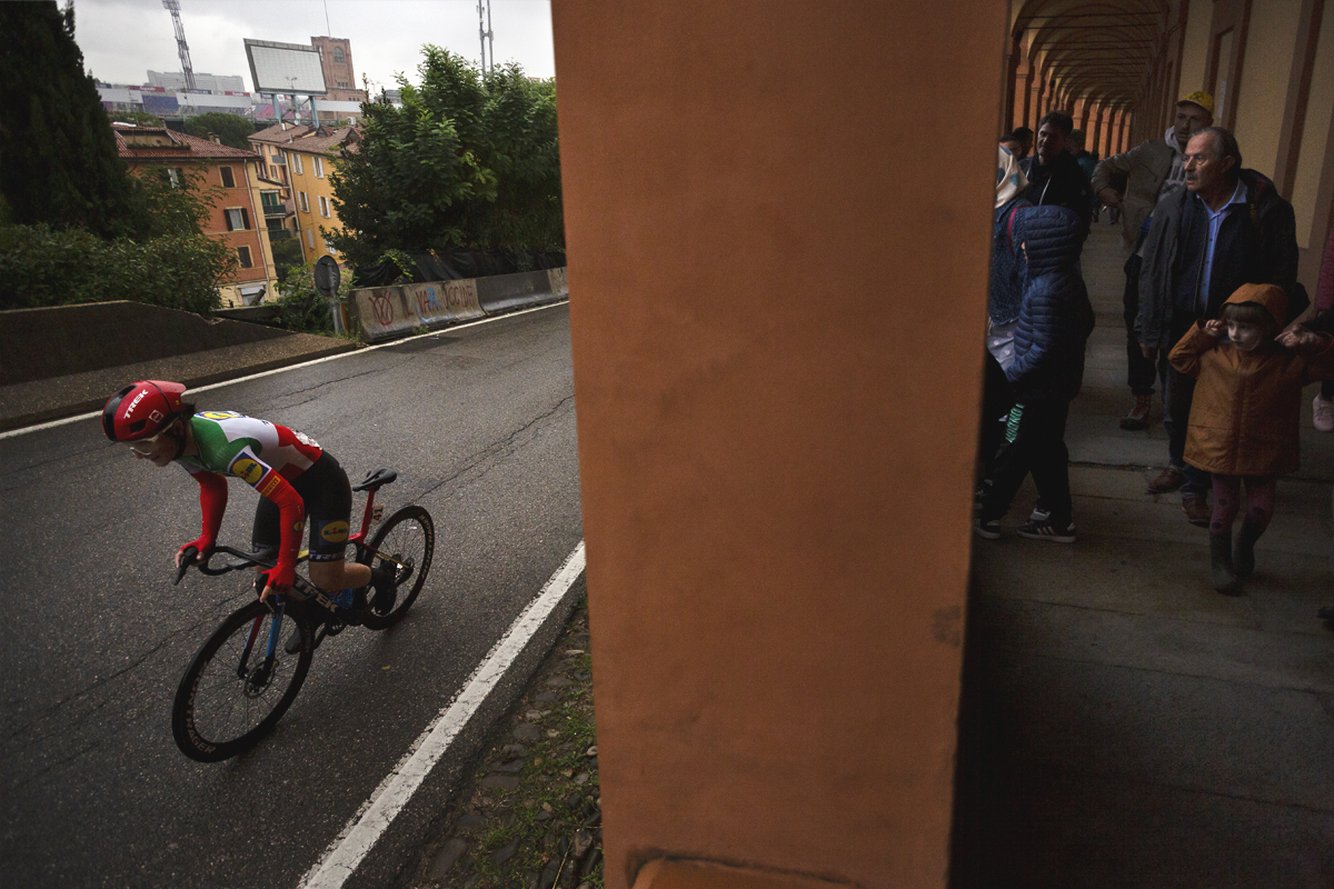Giro dell'Emilia Internazionale Donne Elite 2024 - Elisa Longo Borghini is watched by a young girl from the portico walkway