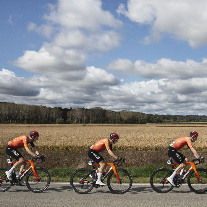 Gran Piemonte 2024 - A line of riders from INEOS Grenadiers with a backdrop of rice fields