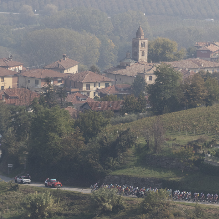 Gran Piemonte 2025 - Riders seen in the Piemonte vineyards with the settlement of Annunziata in the background