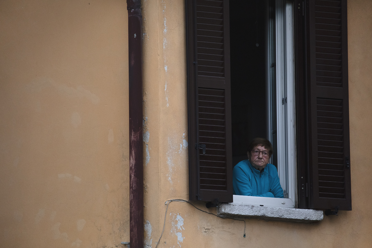 Il Lombardia 2024 - A fan watches out of the window of her home in Como