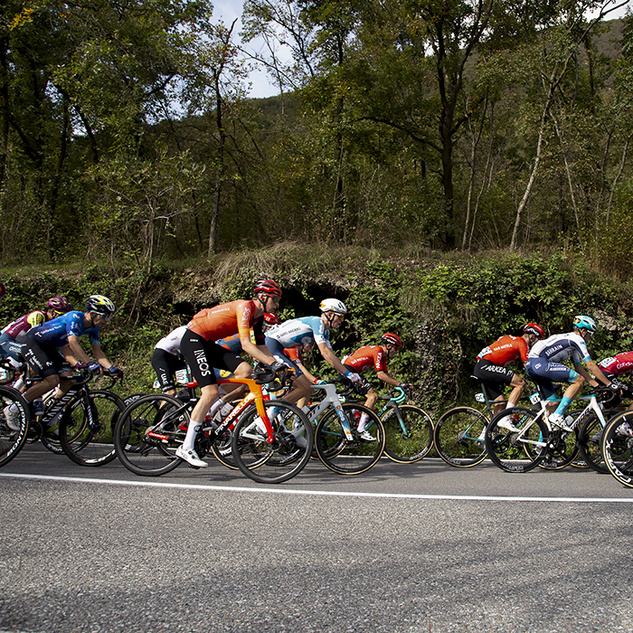 Il Lombardia 2024 - Riders pass caves in the hillside in Dosso