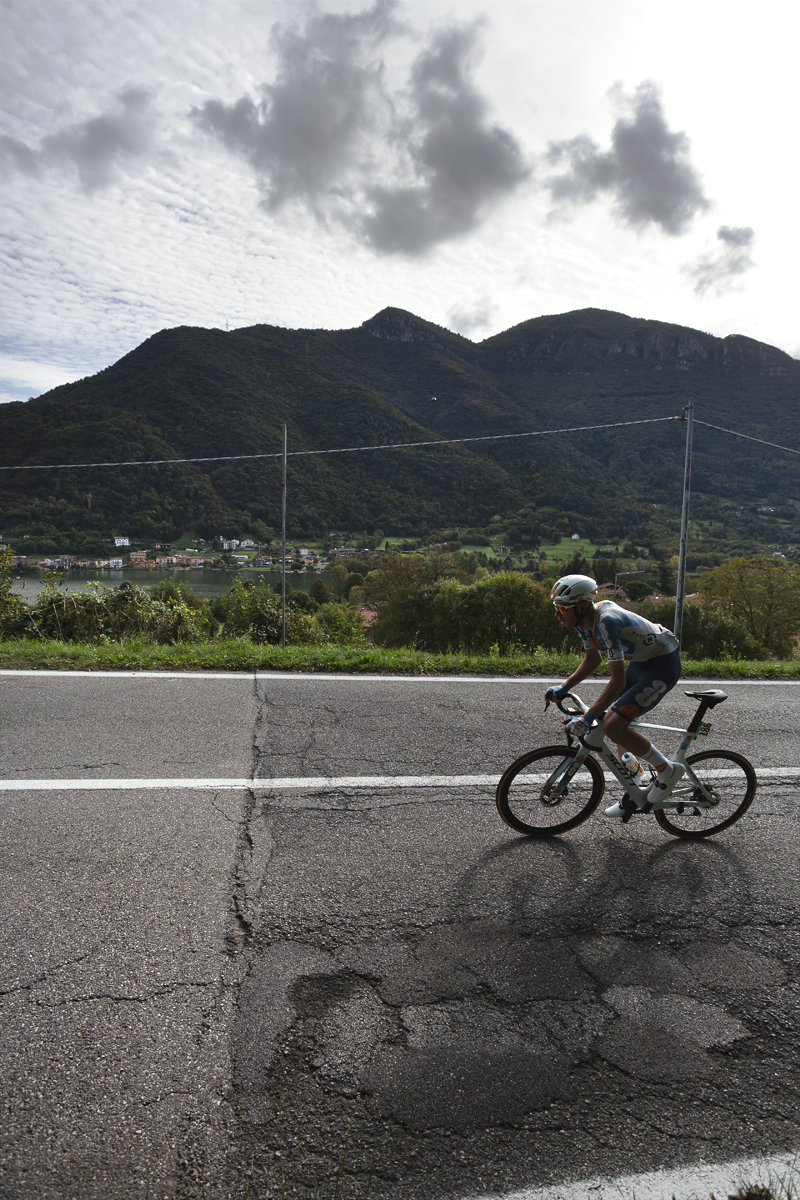 Il Lombardia 2024 - Martijn Tusveld of Team dsm-firmenich PostNL with the Northern Italian lake Lago Di Èndine and hills in the background