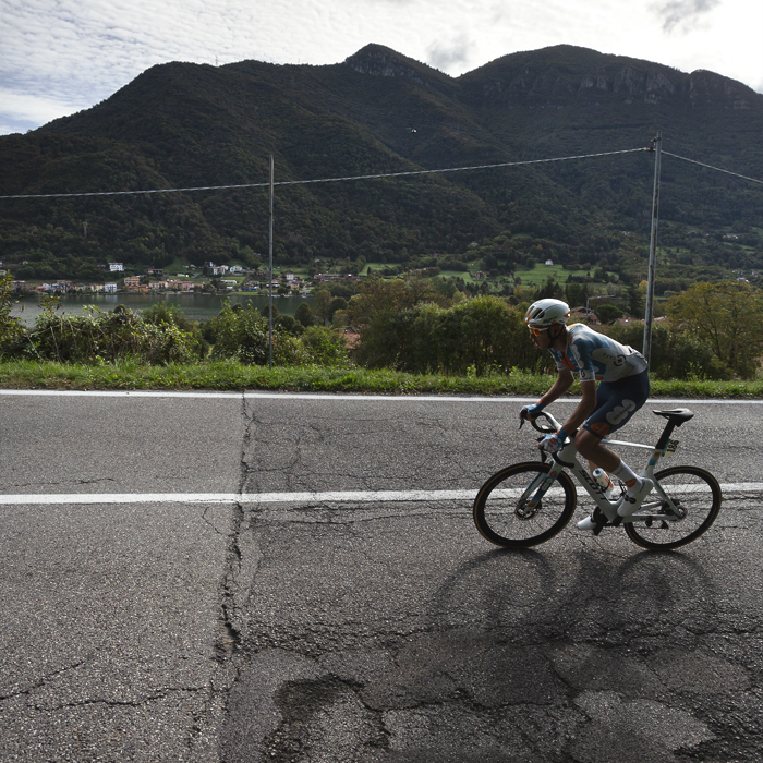 Il Lombardia 2024 - Martijn Tusveld of Team dsm-firmenich PostNL with the Northern Italian lake Lago Di Èndine and hills in the background