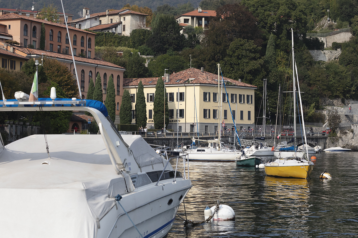 Il Lombardia 2025 - The breakaway viewed across boats moored on the Lago di Lecco