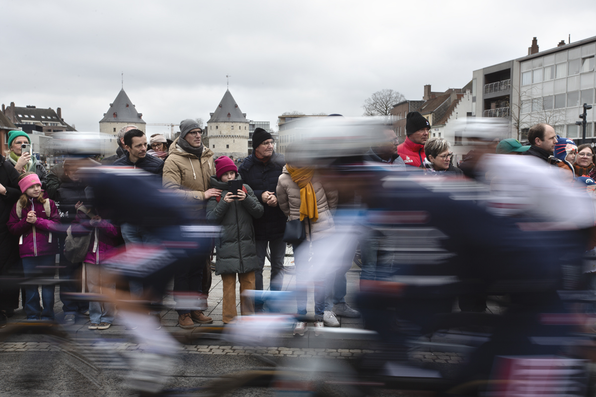 Kuurne Brussel Kuurne 2024 - Riders at the start of the race speed past fans in Kortrijk with the Broeltorens in the background