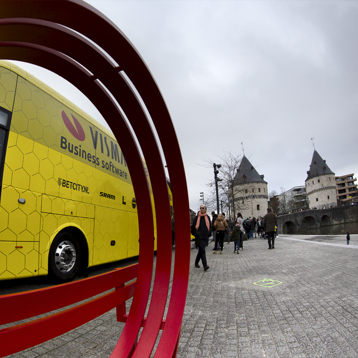 Kuurne Brussel Kuurne 2024 - Team Visma - Lease a Bike bus seen through a bench in the shape of the logo of the race