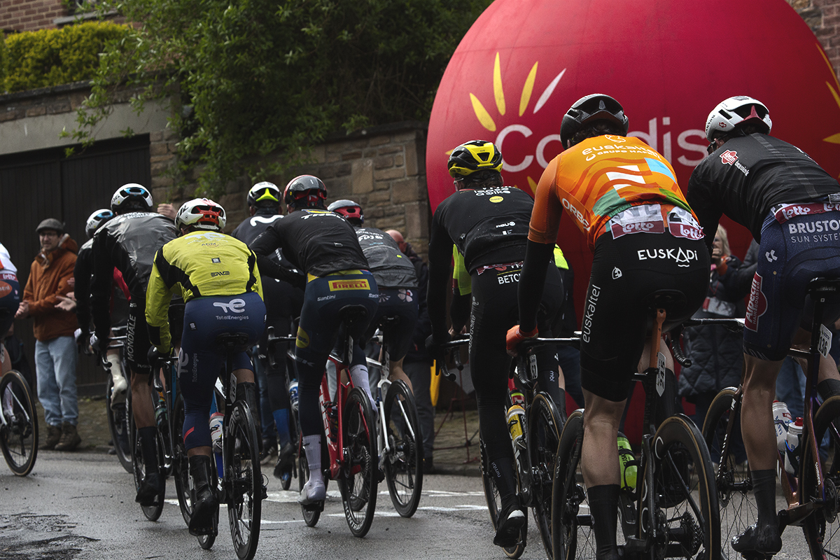 La Flèche Wallonne 2024 - Riders pass an advertising inflatable on the Mur de Huy