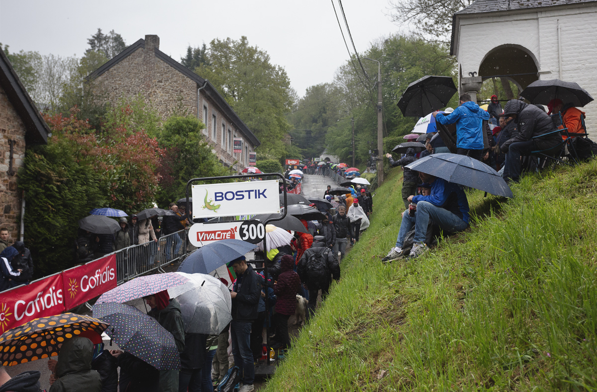 La Flèche Wallonne 2025 - Fans shelter under umbrellas as they wait for the race on the Mur de Huy