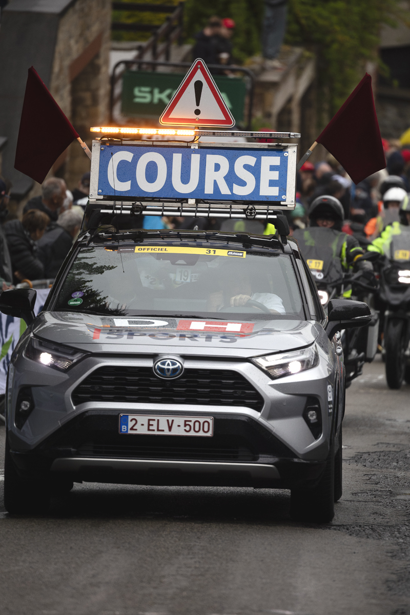 La Flèche Wallonne 2025 - A car announcing the arrival of the riders on the climb