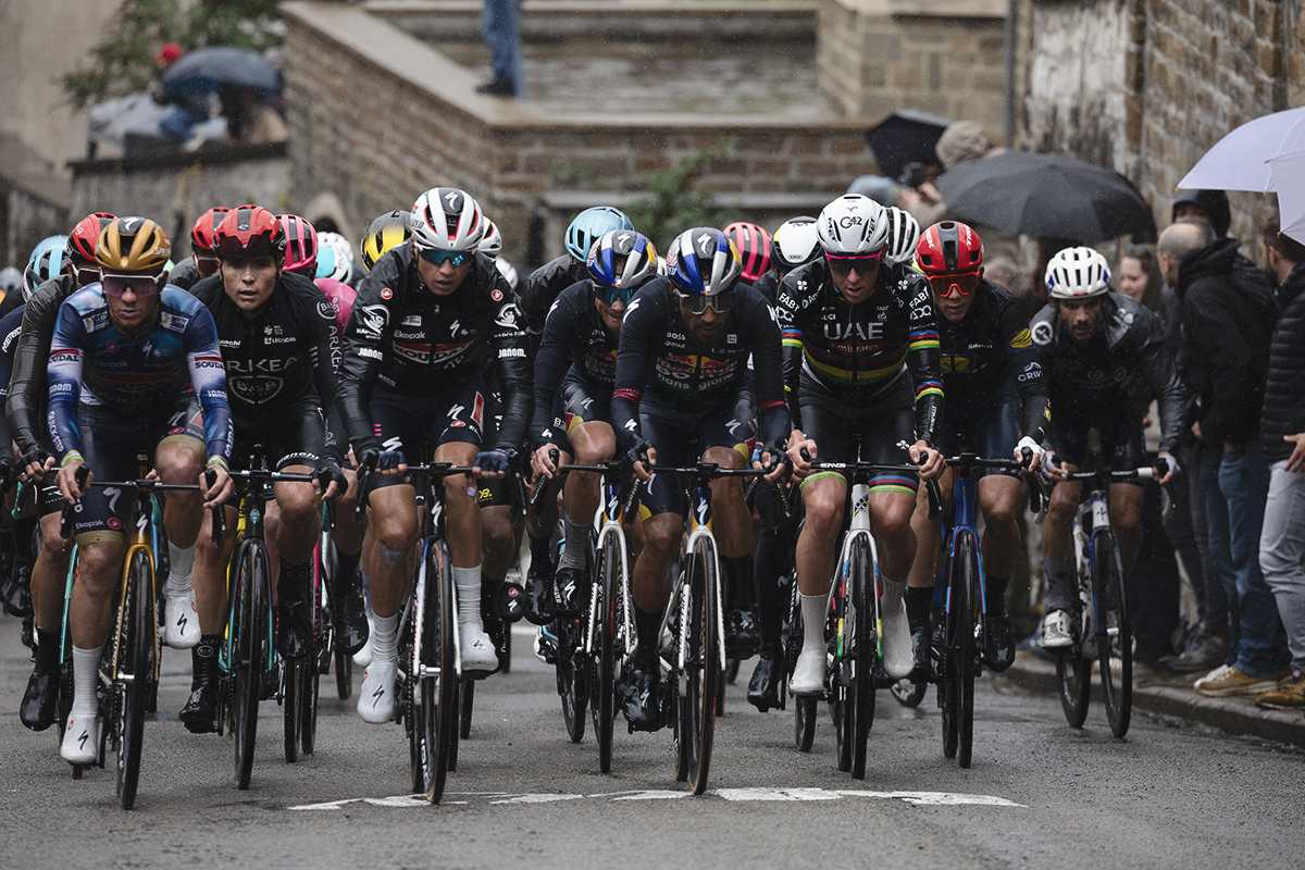 La Flèche Wallonne 2025 - The peloton on the Mur de Huy, riders covered in their rain jackets to protect against the challenging conditions