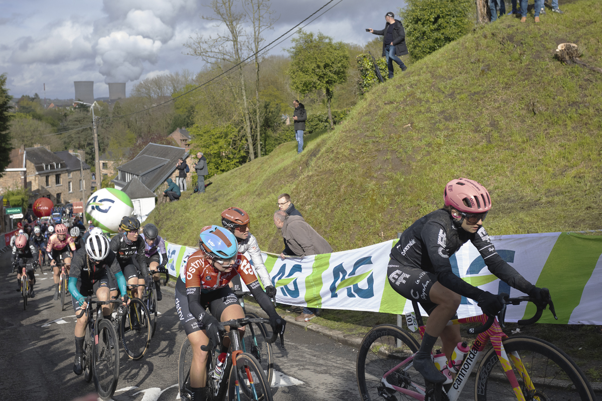 La Flèche Wallonne Femmes 2024 - A group of riders pass a grassy mound on the Mur de Huy