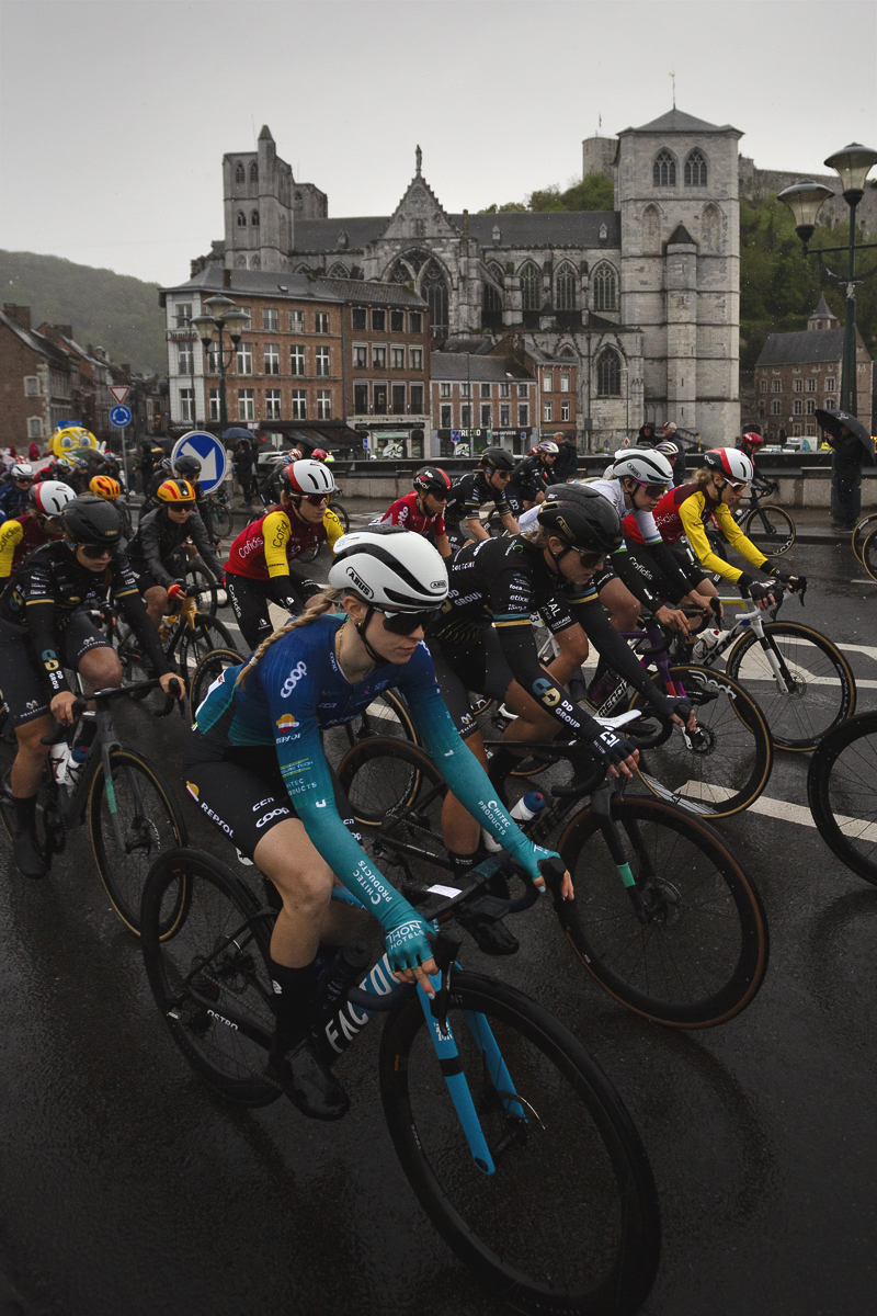 La Flèche Wallonne Femmes 2025 - Collégiale Notre-Dame et Saint-Domitien is seen in the background as the race crosses the river