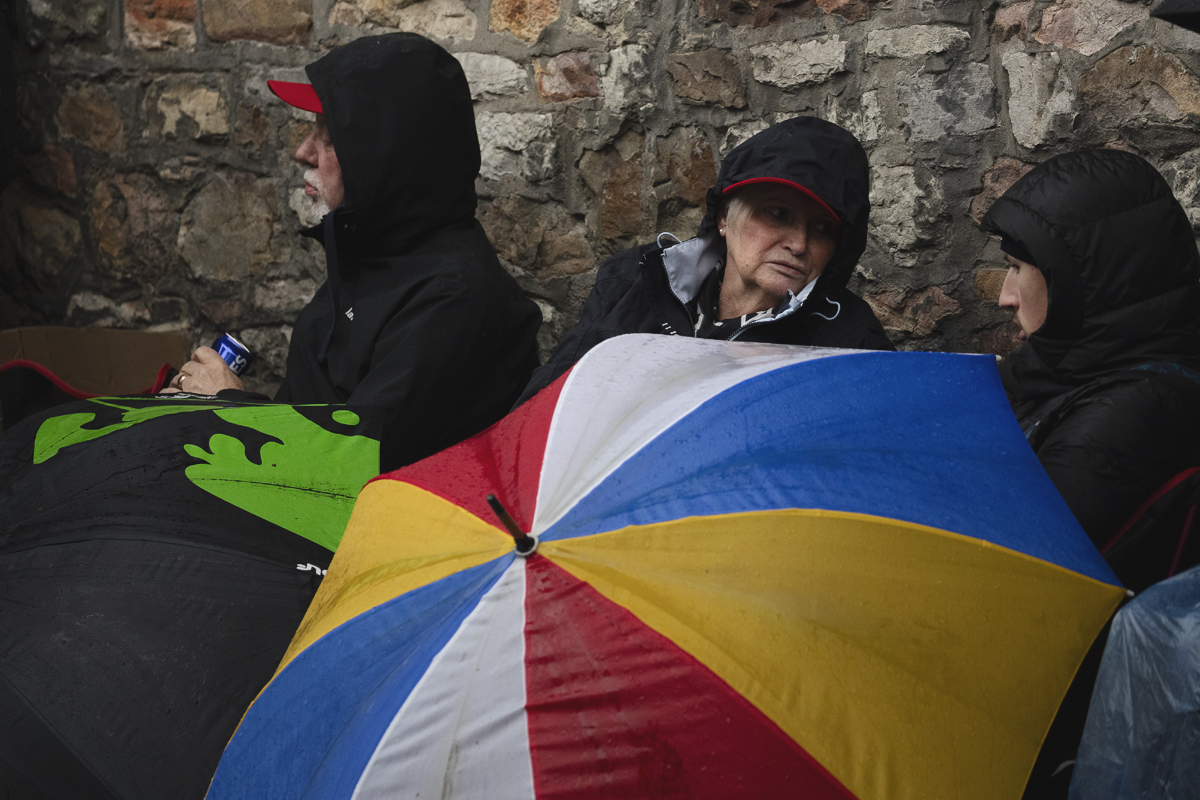 La Flèche Wallonne Femmes 2025 - Fans sit with brightly coloured umbrellas waiting for the race