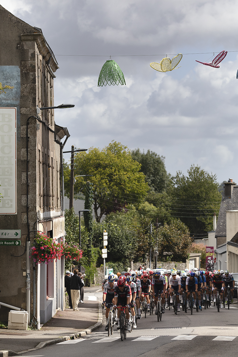 Bretagne Classic - Ouest-France 2025 - The peloton approaches in Châteauneuf-du-Faou