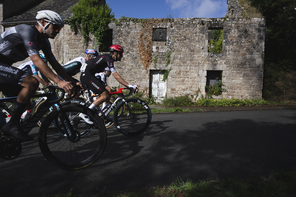 Bretagne Classic - Ouest-France 2025 - Riders pass in front of a dilapidated stone house with no roof during the race