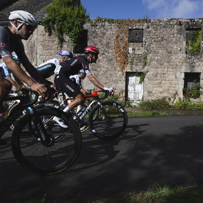 Bretagne Classic - Ouest-France 2025 - Riders pass in front of a dilapidated stone house with no roof during the race
