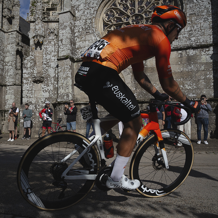 Bretagne Classic - Ouest-France 2025 - Andoni López de Abetxuko rounds a corner in front of a beautiful old church in Kernascléden