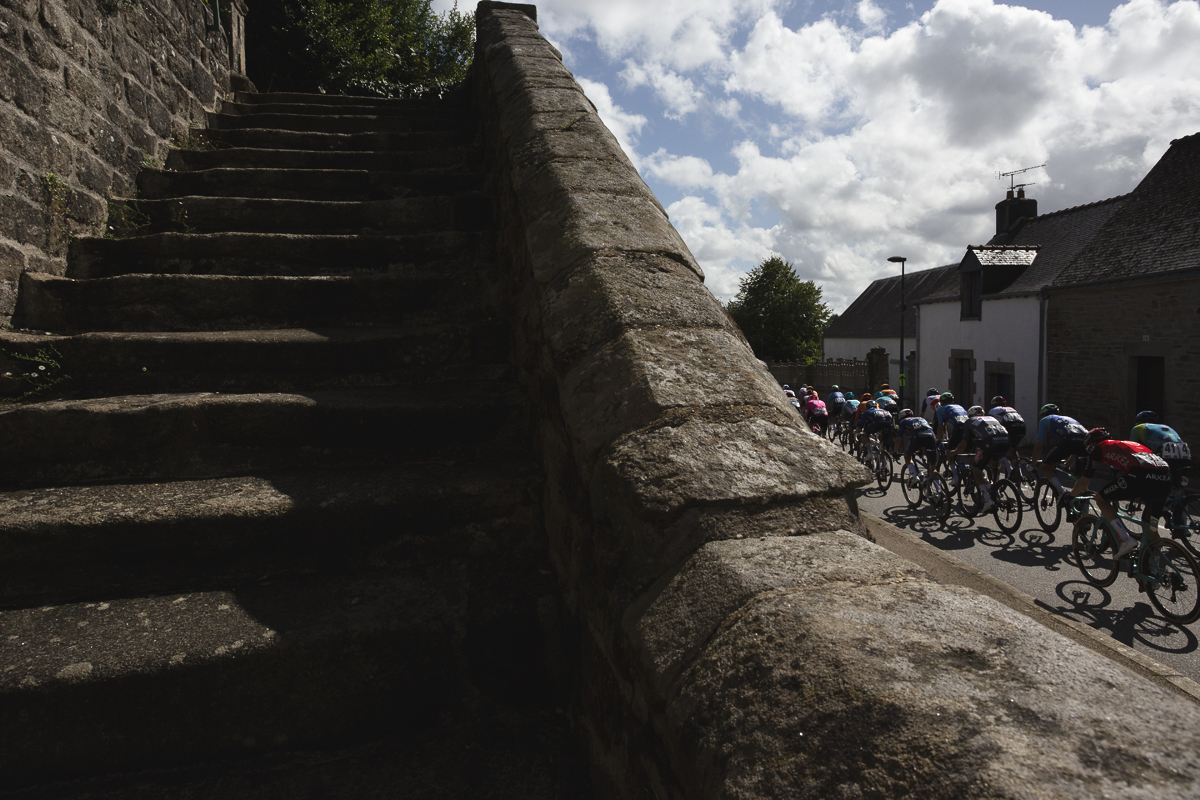 Bretagne Classic - Ouest-France 2025 - The peloton passes by a set of stone steps in Le Saint