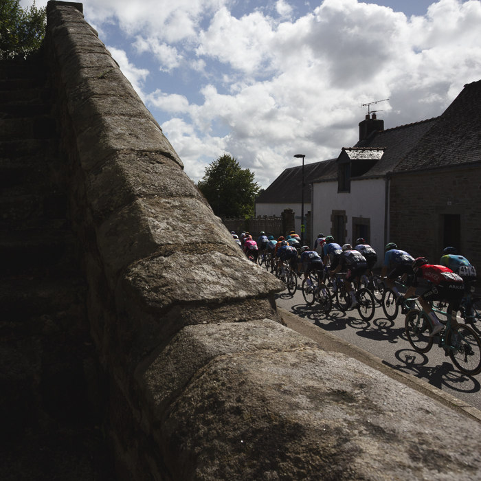 Bretagne Classic - Ouest-France 2025 - The peloton passes by a set of stone steps in Le Saint
