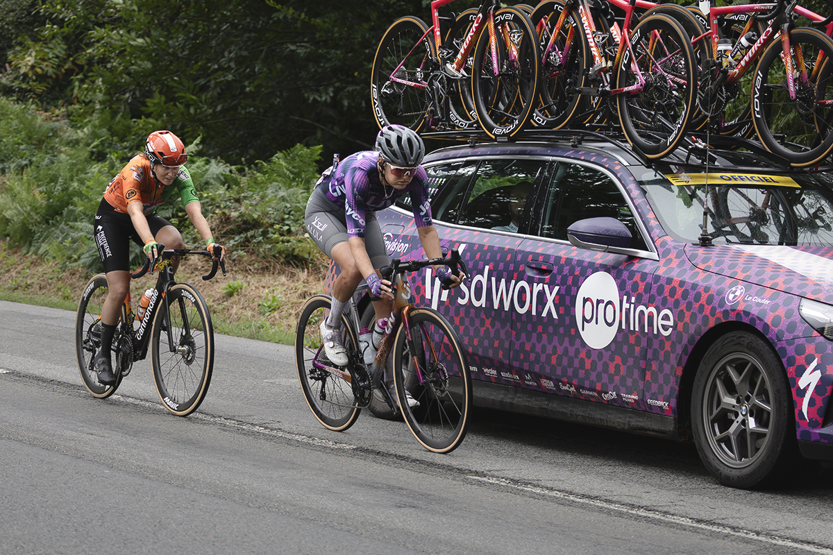 Classic Lorient Agglomération - Ceratizit 2025 - Alicia González and Jeanne Korevaar cycle next to a rivals team’s car