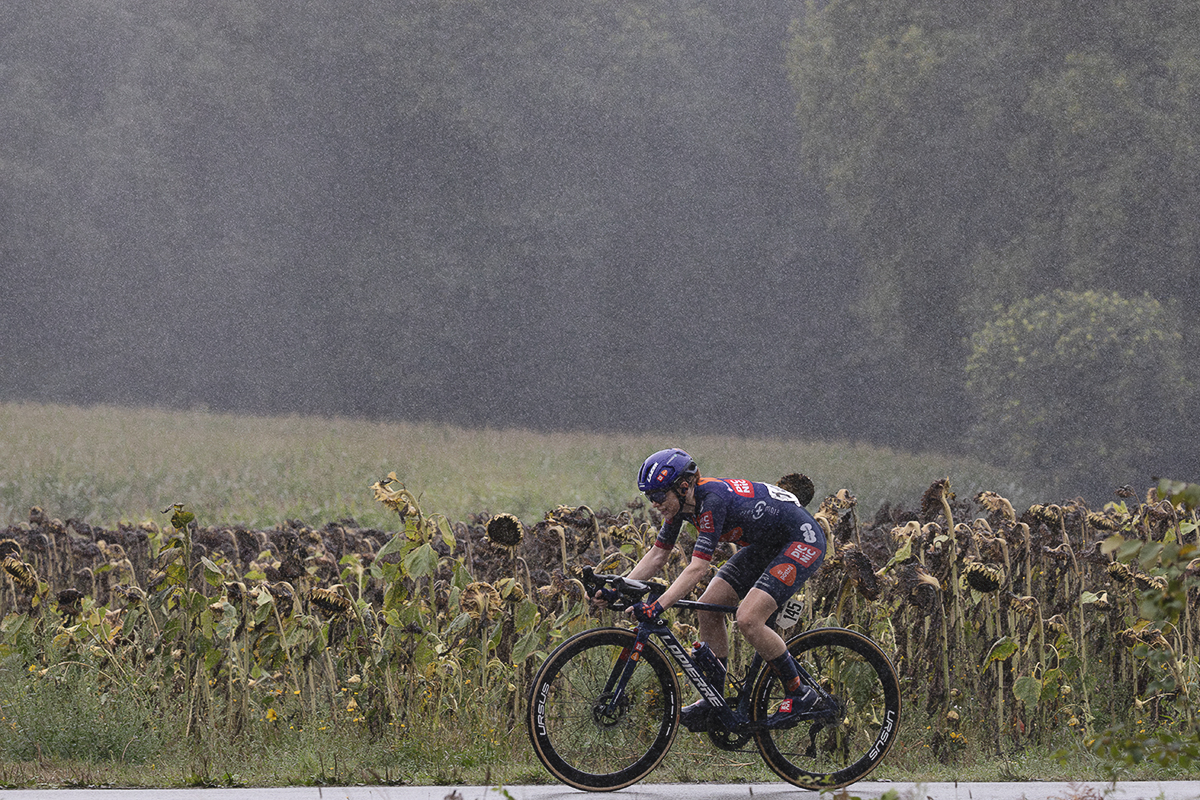 Classic Lorient Agglomération - Ceratizit 2025 - Josie Nelson rides through the pouring rain passing in front of a field of dead sunflowers