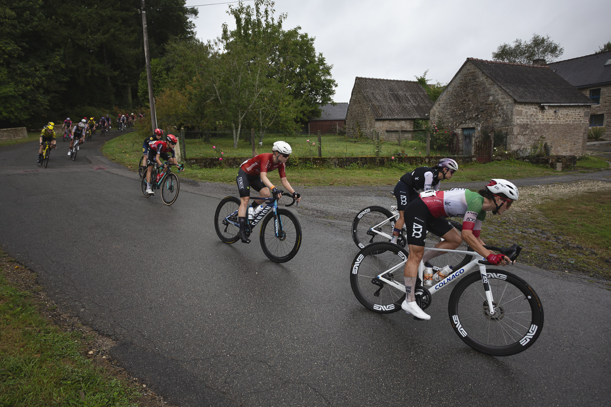 Classic Lorient Agglomération - Ceratizit 2025 - Riders pass in front of stone farm buildings at Le Temple