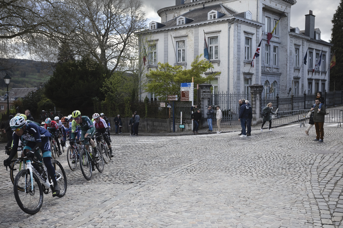 Liège-Bastogne-Liège 2024 - Riders round a corner on a cobbled street in Stavelot