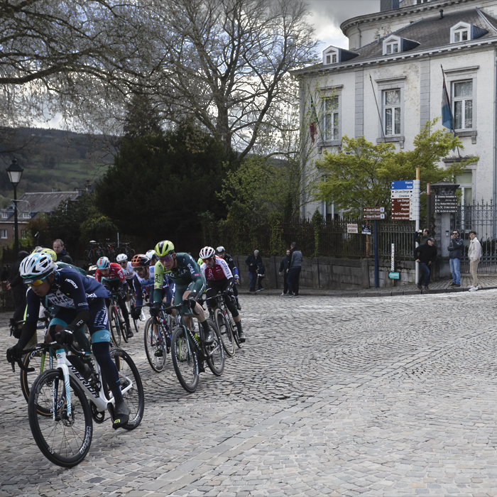 Liège-Bastogne-Liège 2024 - Riders round a corner on a cobbled street in Stavelot