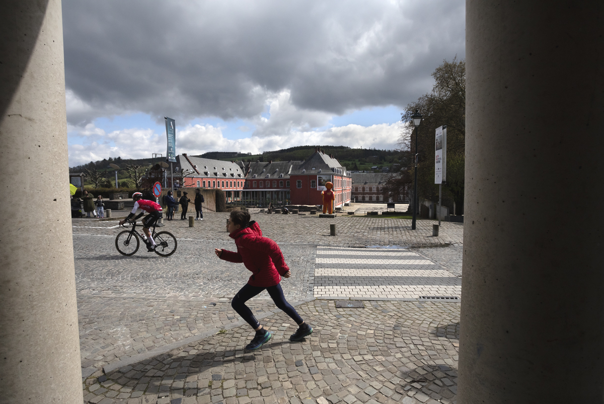 Liège-Bastogne-Liège 2024 - A child wearing red sprints after a Cofidis rider in Stavelot
