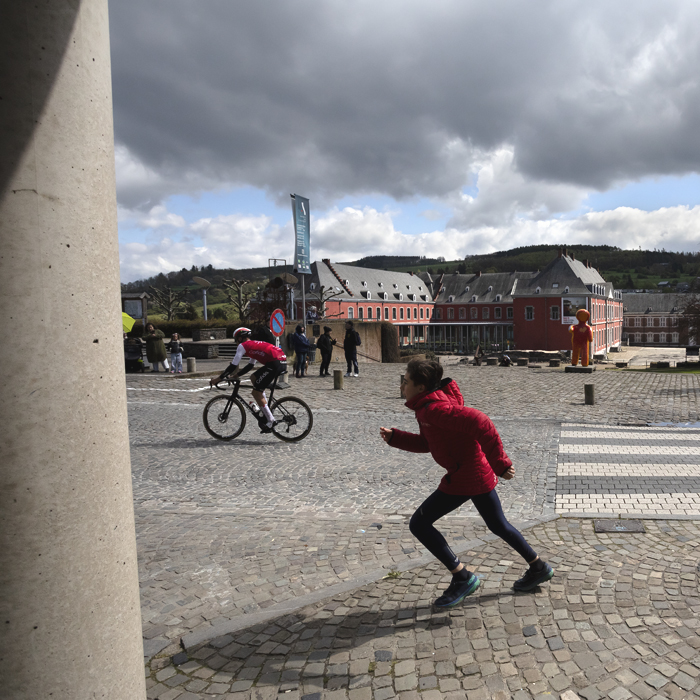 Liège-Bastogne-Liège 2024 - A child wearing red sprints after a Cofidis rider in Stavelot