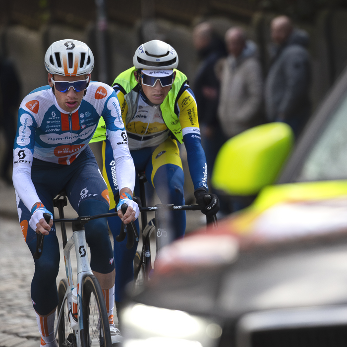 Liège-Bastogne-Liège 2024 - Martijn Tusveld & Lars Craps framed by a race vehicle