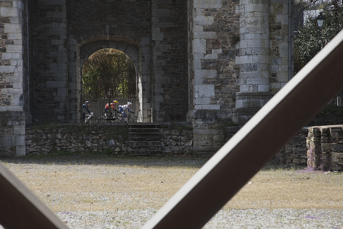 Liège-Bastogne-Liège 2024 - Riders framed by an arch in the Toren Abdijkerk, Stavelot