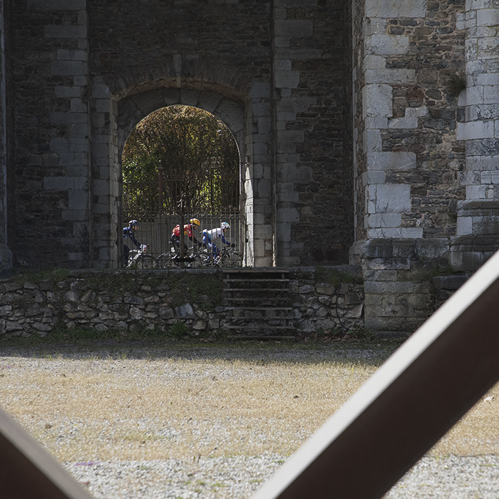 Liège-Bastogne-Liège 2024 - Riders framed by an arch in the Toren Abdijkerk, Stavelot