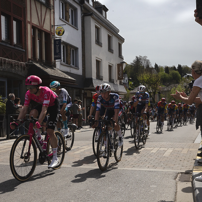 Liege Bastogne Liege 2025 - The peloton is cheered on by crowds lining the streets at La Roché-en-Ardenne