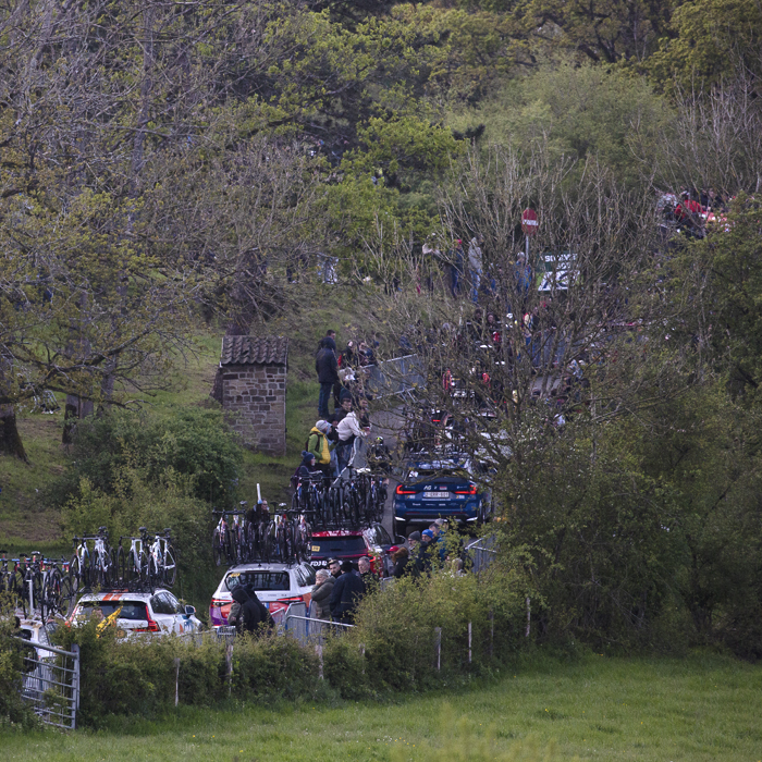 Liège-Bastogne-Liège Femmes 2024 - The convoy of team cars seen across the fields on Côte de la Redoute