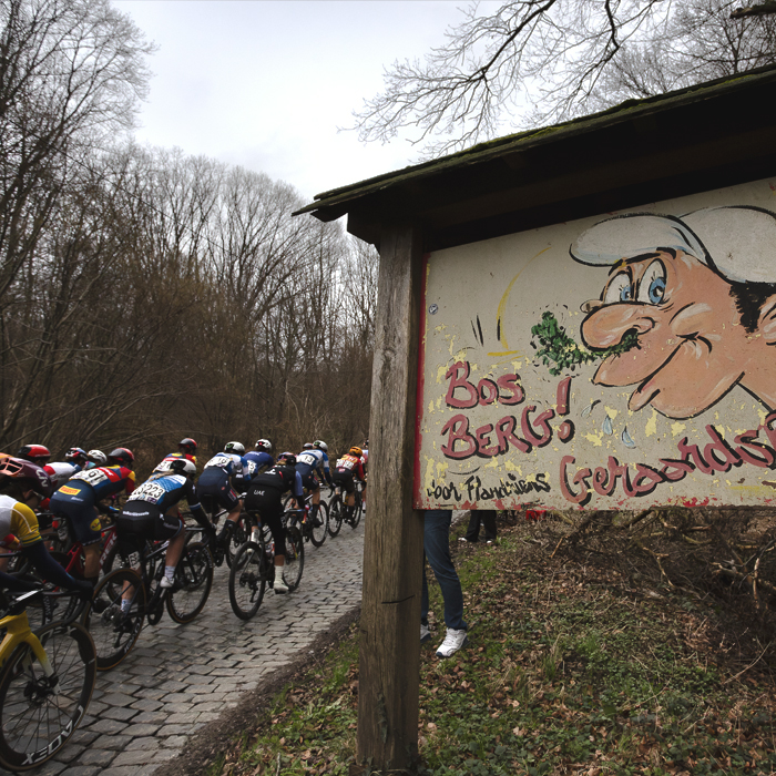 Omloop Het Nieuwsblad Vrouwen 2024 - The peloton passes the iconic old sign for the Bosberg