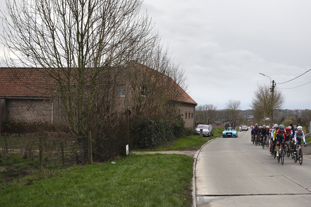 Omloop Het Nieuwsblad Vrouwen 2024 - riders pass a farmhouse on the concrete road of Kapellestraat
