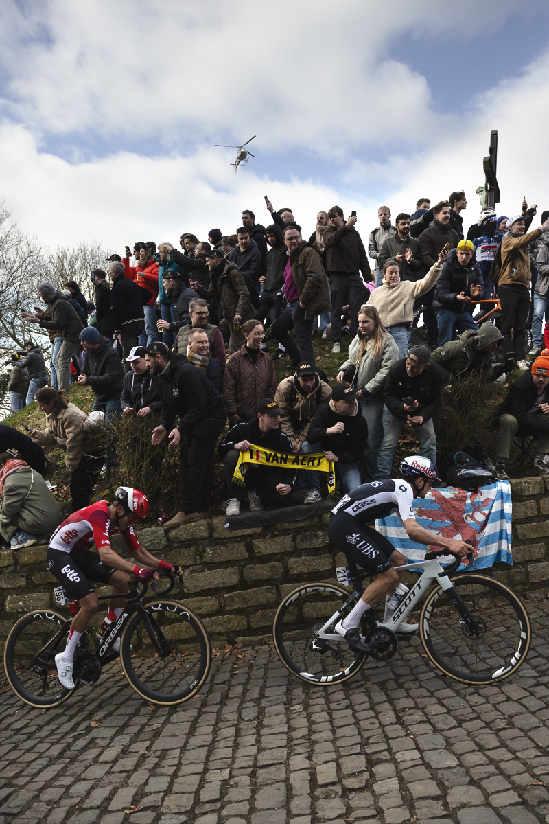 Omloop Nieuwsblad 2025 - Tom Pidcock of Q36.5 Pro Cycling Team & Arjen Livyns of Lotto, passes enthusiastic fans on the Muur van Geraardsbergen