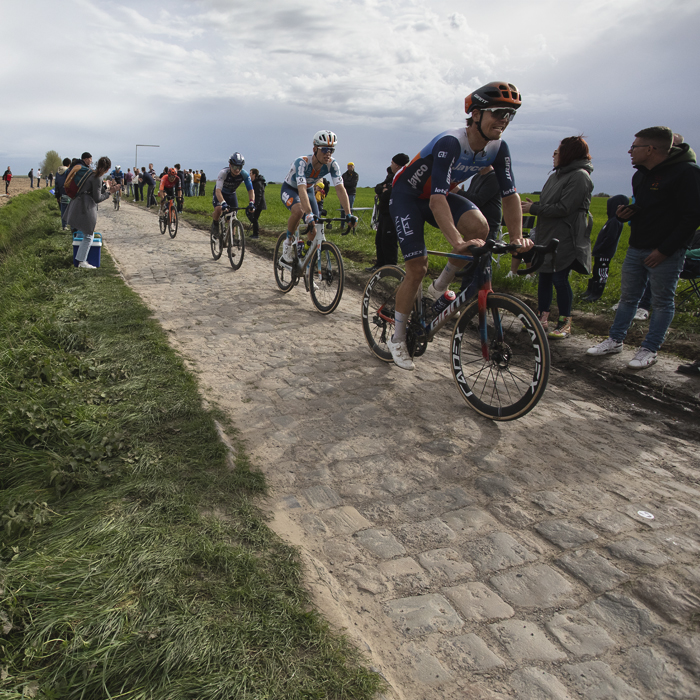 Paris Roubaix 2024 - A red balloon at the side of the race with fans watching on at Camphin-en-Pévèle