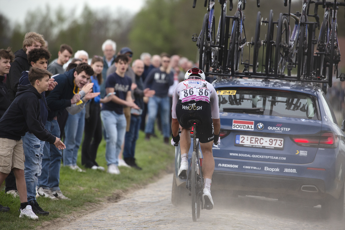 Paris Roubaix 2024 - António Morgado of UAE Team Emirates follows a race car on Camphin-en-Pévèle