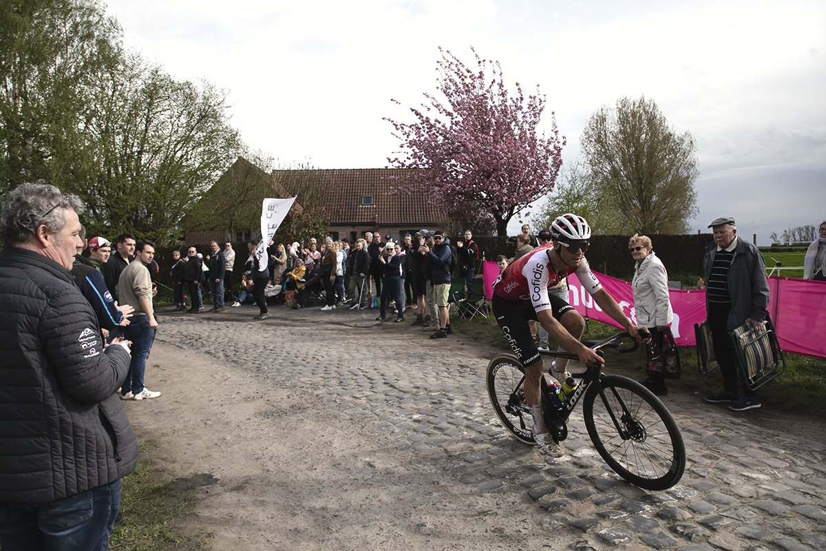 Paris Roubaix 2024 - Milan Fretin of Cofidis rounds a corner past a blossom laden tree on Carrefour de l’Arbre 