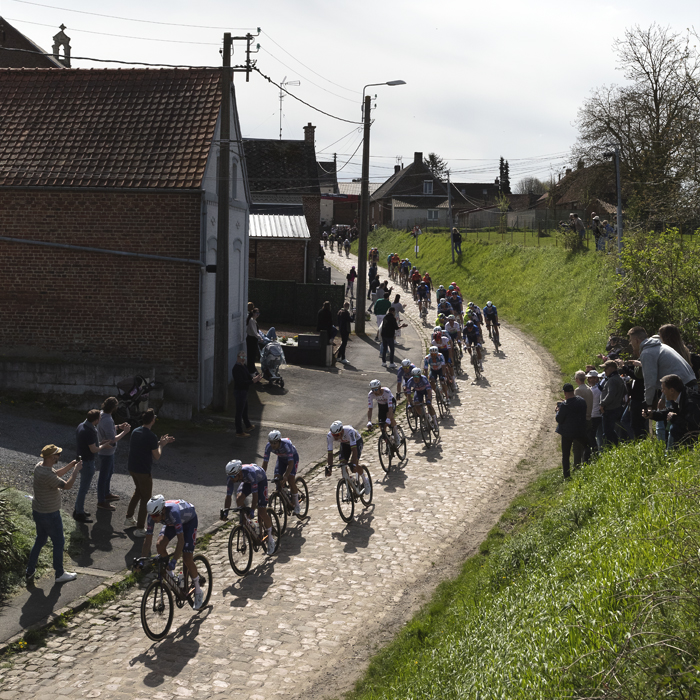 Paris Roubaix 2024 - A strung out group of riders enters the Quiévy à Saint-Python sector