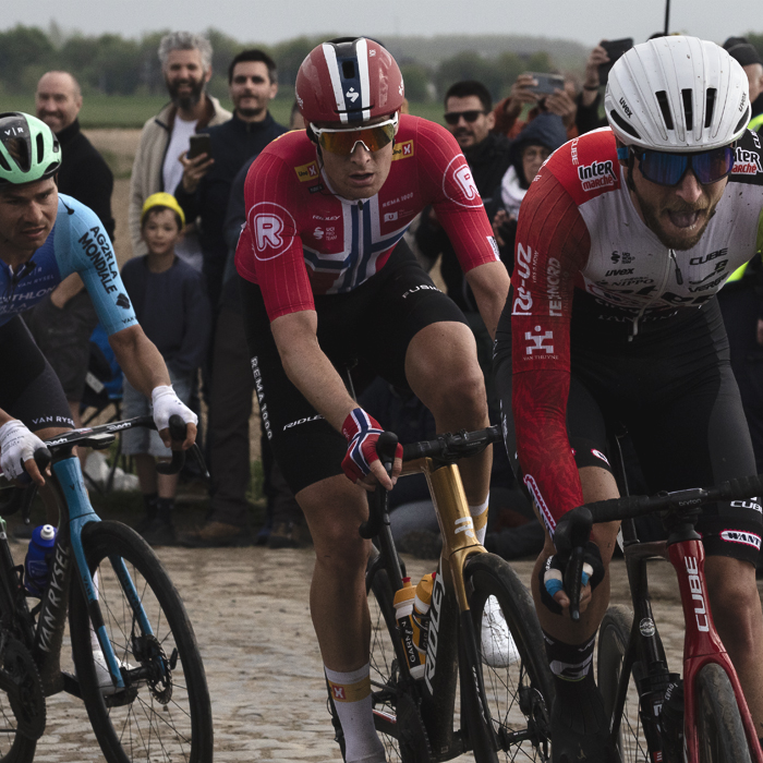 Paris Roubaix 2025 - A group of riders are watched on by fans during the race