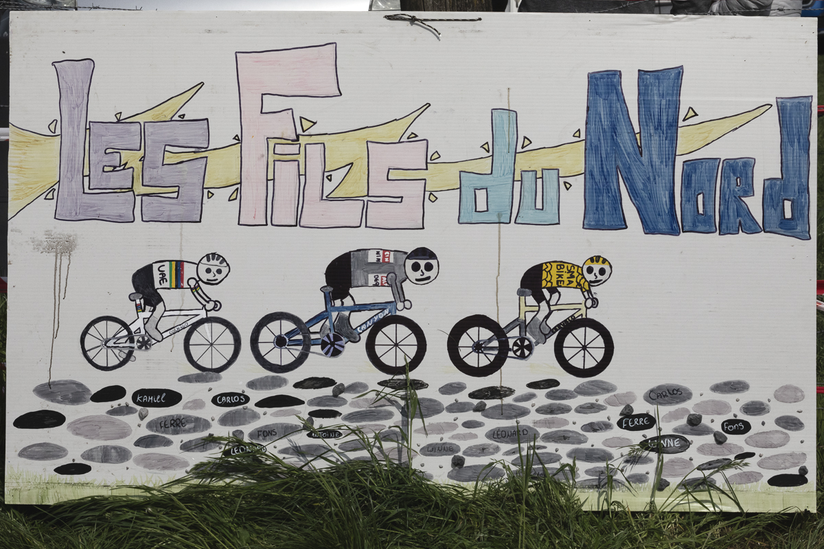 Paris Roubaix 2025 - A children’s home made sign depicts three of the race favourites - Les Fils du Nord - The Sons of the North