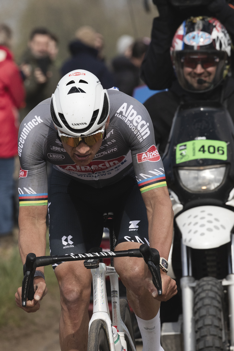 Paris Roubaix 2025 - Mathieu van der Poel with determination showing on his face is followed closely by the TV motorbike